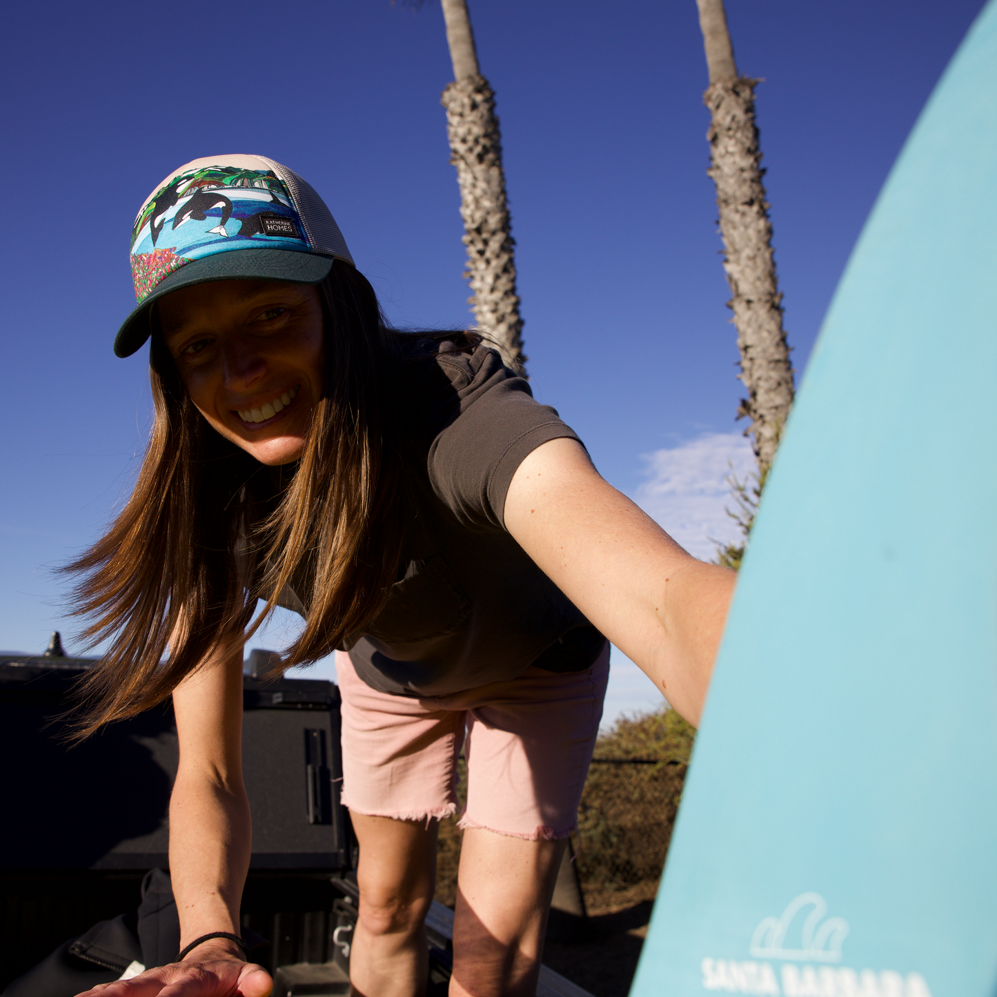 Surfer wearing Wild Orcas San Juan Islands Trucker  Hat Baseball Cap Recycled Fabrics mesh adjustable Hat by artist  Katherine Homes
