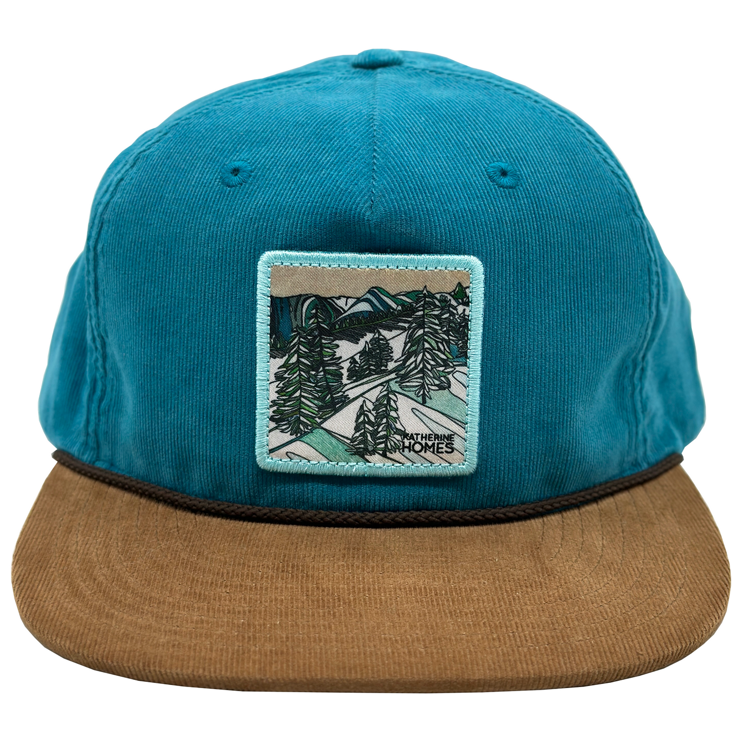 Blue cap with a brown brim and nature-themed patch featuring snowy trees